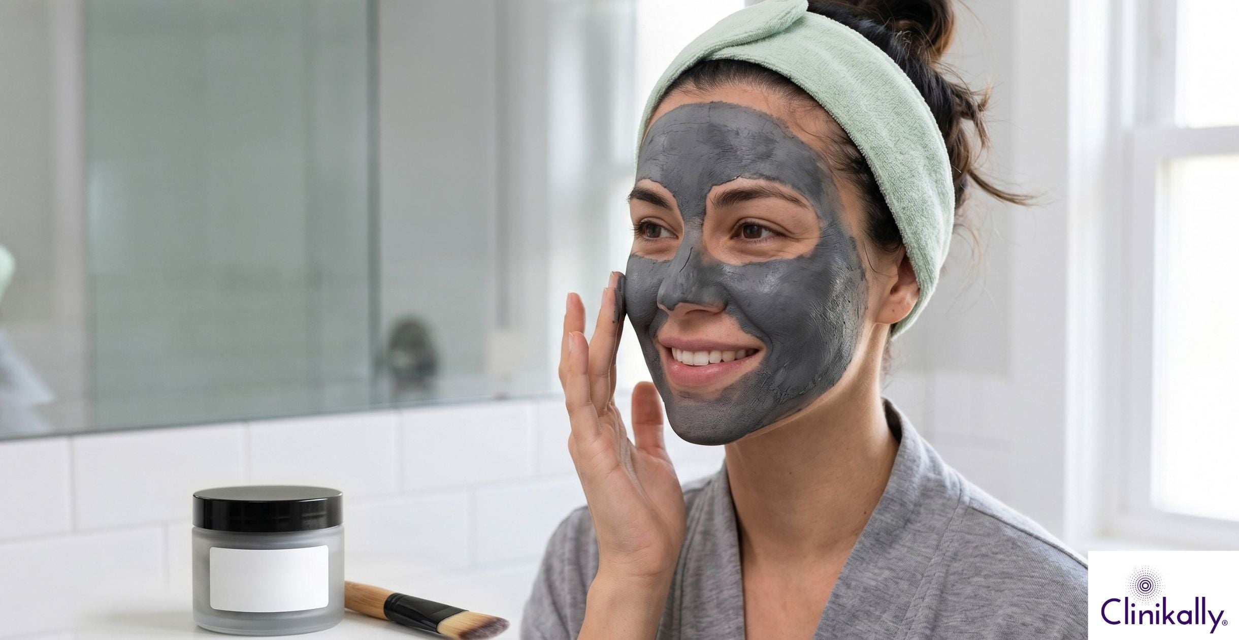 Woman applying charcoal clay face mask for oily skin care