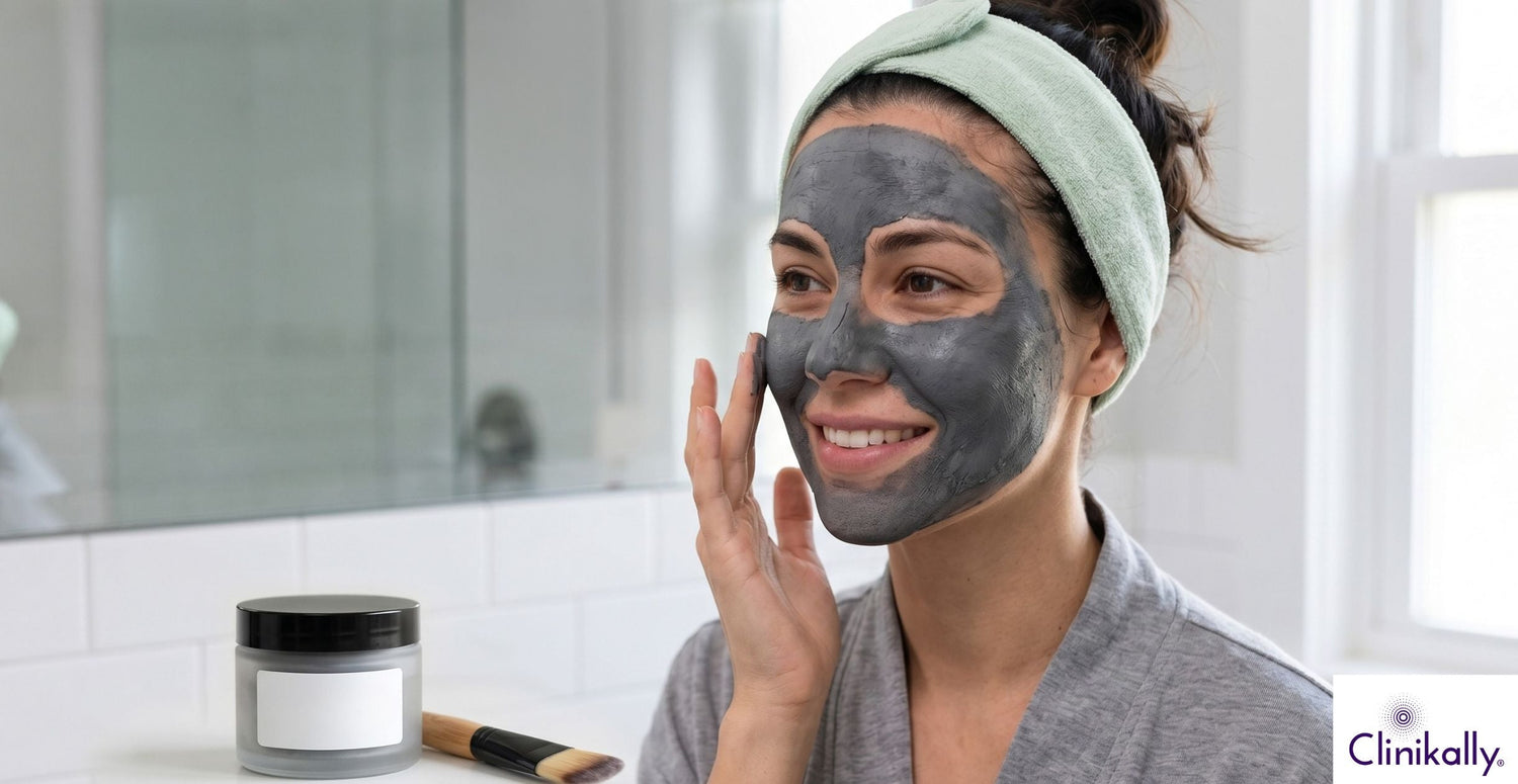 Woman applying charcoal clay face mask for oily skin care